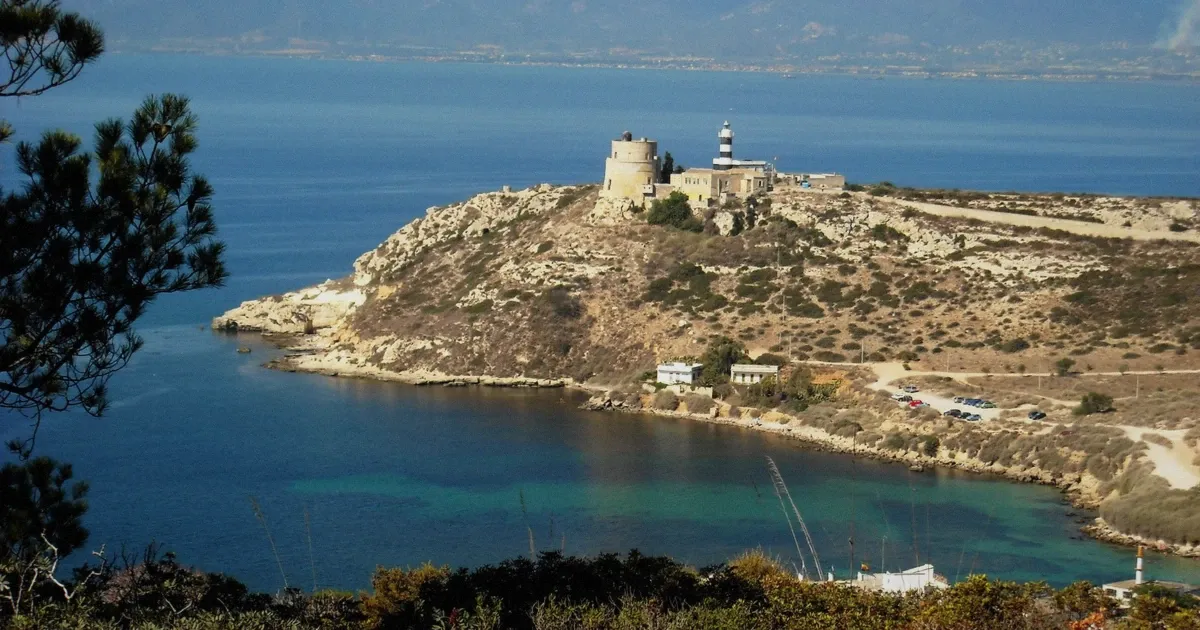 Calamosca tower and lighthouse on the Cagliari coast seen from the sea during the Blue Safari boat tour