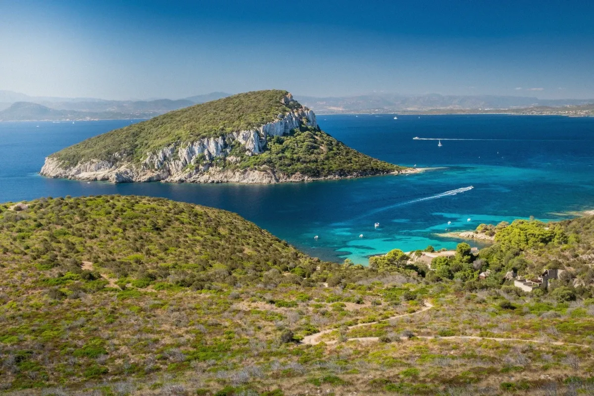 Panoramic view of Cala Fighera cove with cliffs on three sides, a stop on the private gozzo charter from Cagliari